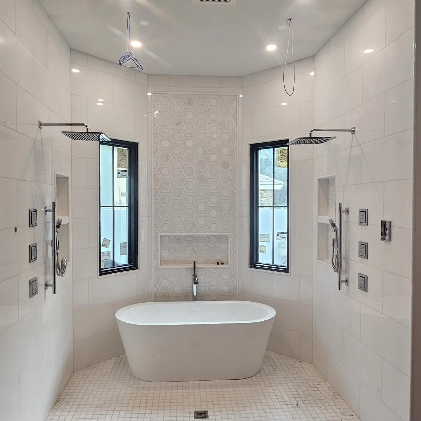 Luxury primary bathroom with dual rain showers and freestanding tub