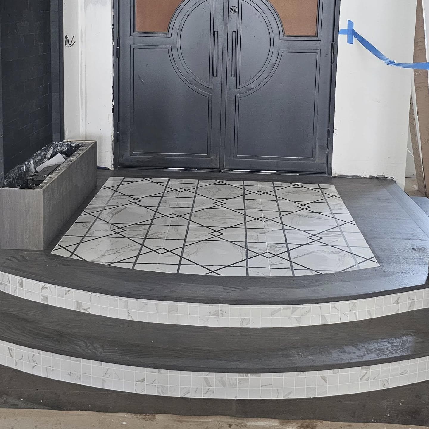 Front entry geometric marble tile with curved mosaic-edge steps