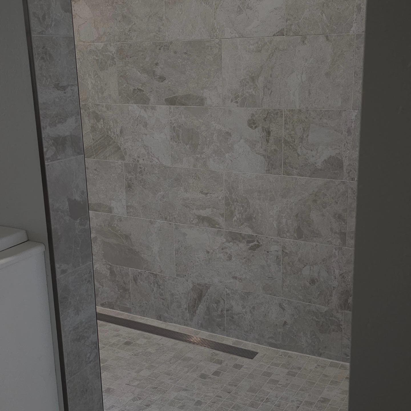 Gray large-format tile shower with linear drain